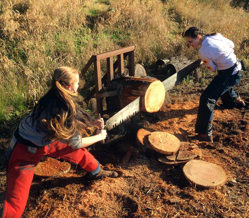 Two Clatskanie girls cut into a log. It was worth a buck.