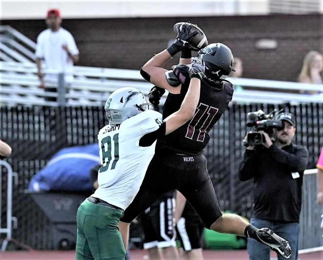 Tualatin's Richie Anderson (11) goes up to catch a touchdown pass against Summit's Ethan Carlson. (Photo by Jon Olson)
