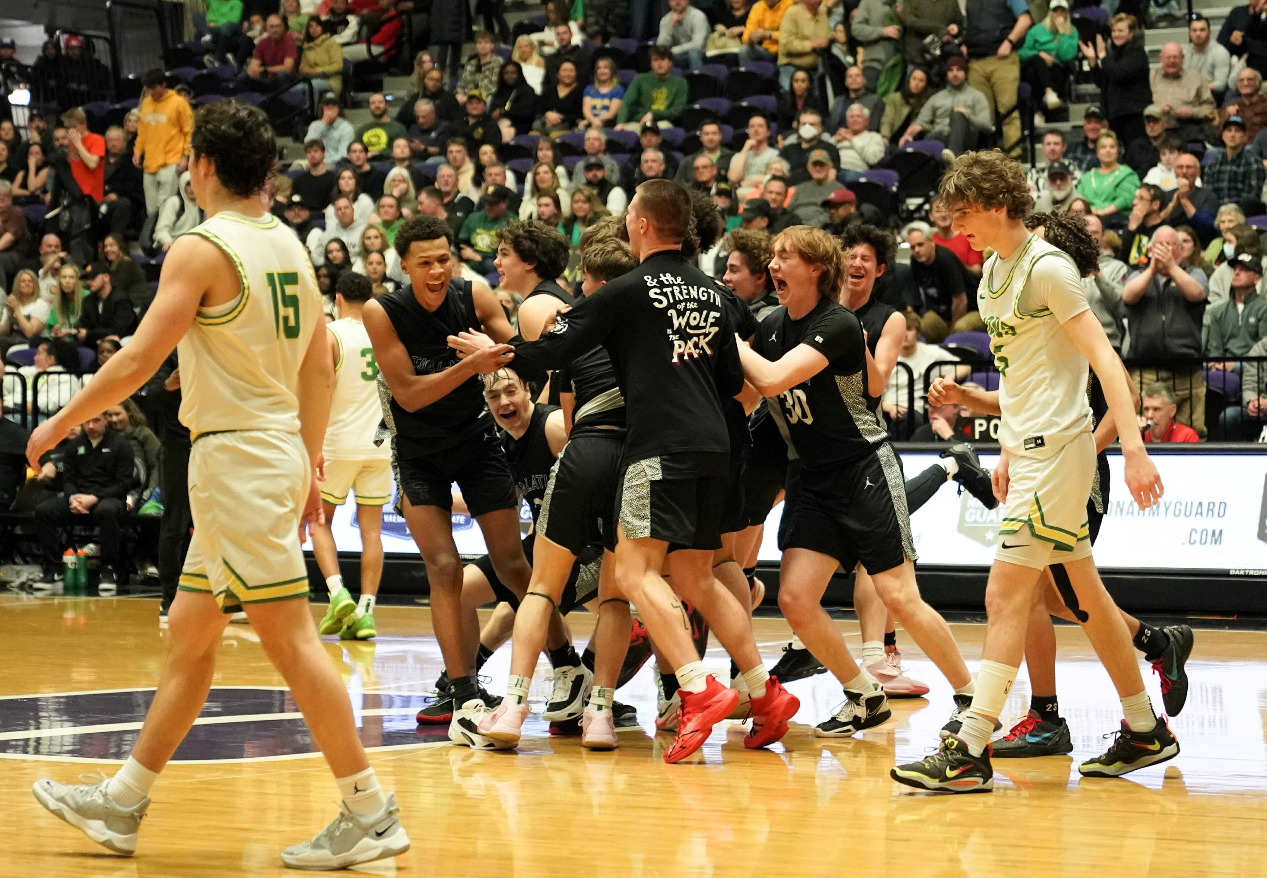 Tualatin players celebrate after upsetting top-seeded West Linn in the 6A boys basketball final Saturday. (Photo by Jon Olson)
