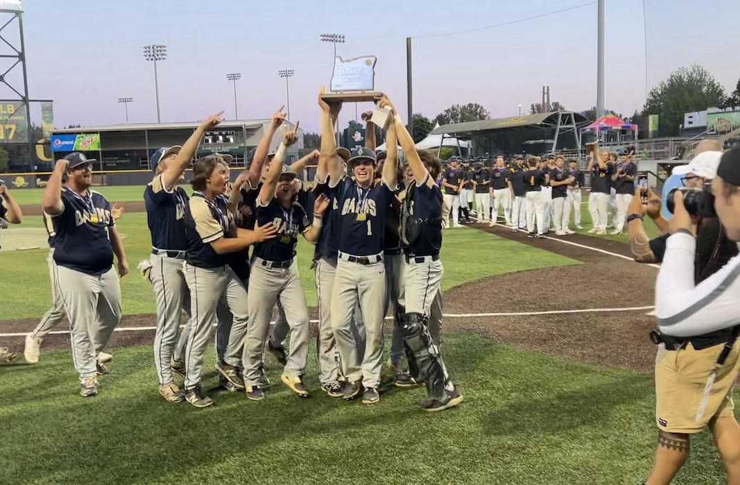 Banks' Wyatt Hesselman (holding trophy) celebrates a 3A state championship with his teammates Saturday at PK Park.