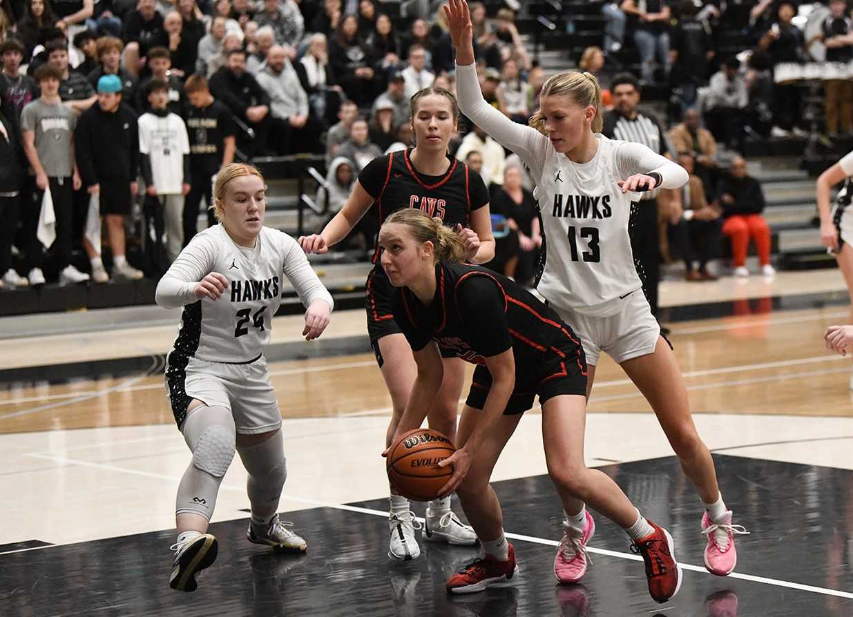 Clackamas' Dylan Mogel drives against Nelson's Ella Schackleton (24) and Lainey Day (13). (Photo by Fanta Mithmeuangneua)