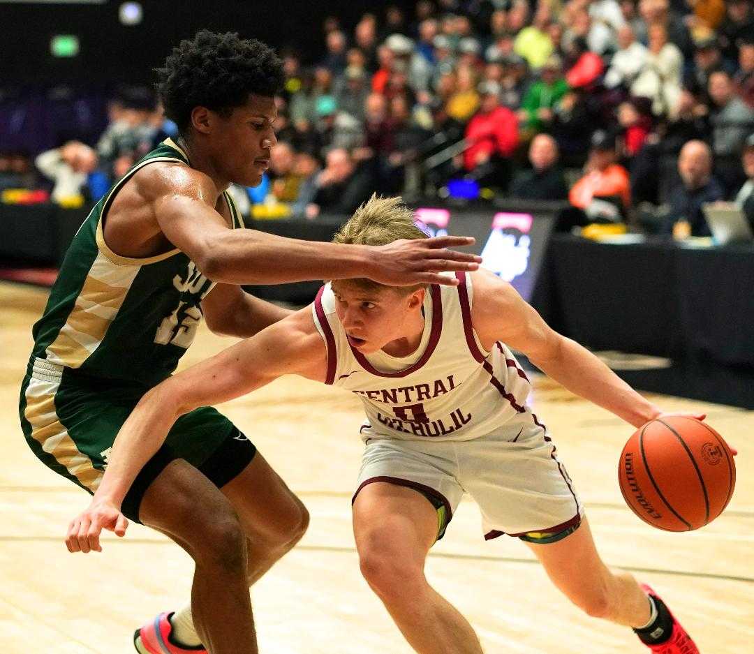 Central Catholic's Isaac Carr drives against Jesuit's Isaac Bongen in Wednesday's quarterfinal game. (Photo by Jon Olson)