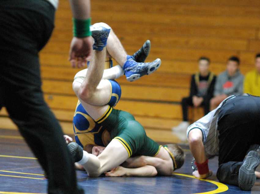 Sophomore Ricky Bell (in green) recorded a technical fall for West Linn at 113 by putting his opponent often on his back