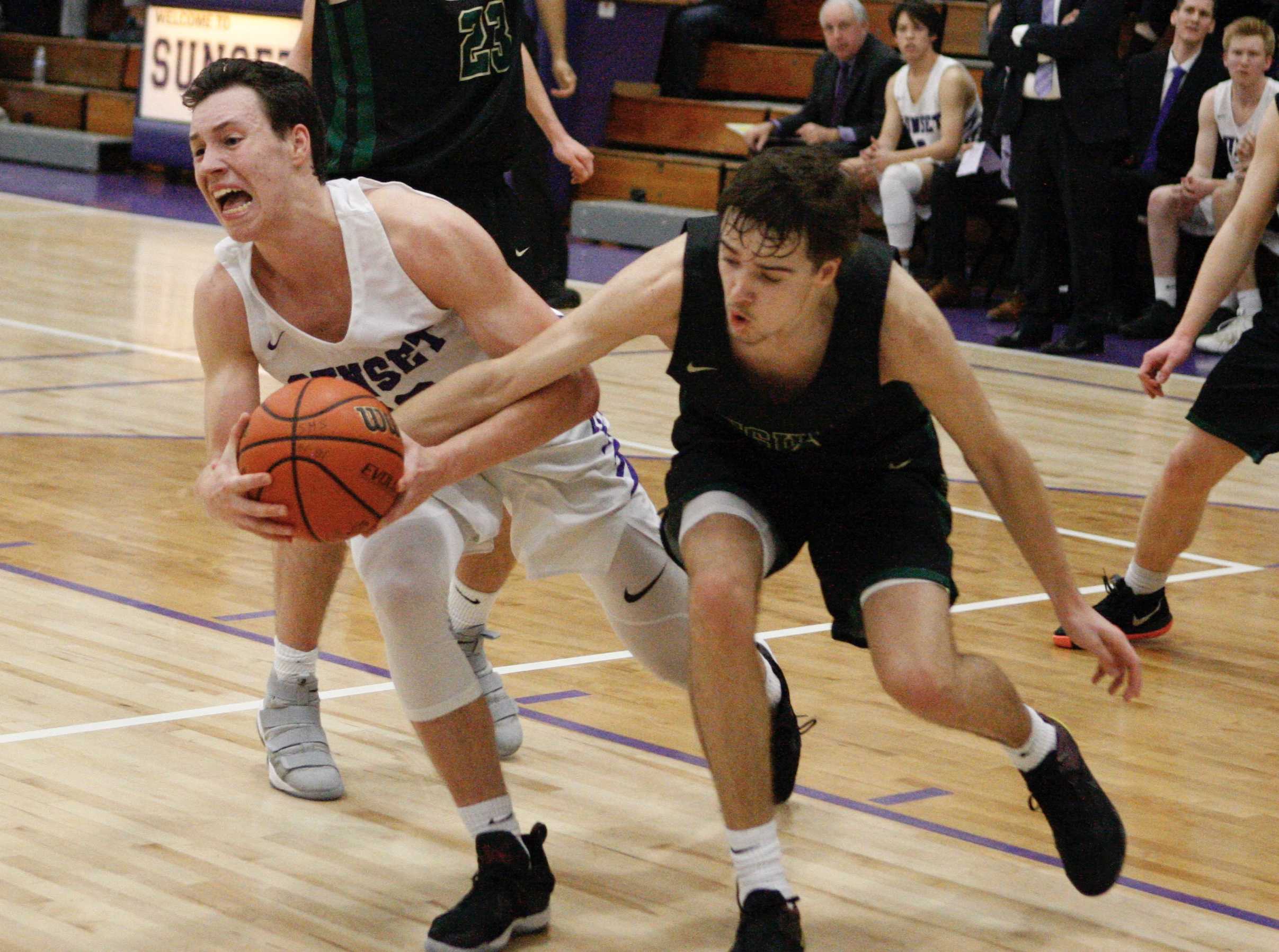 Sunset's Colby King wrestles the ball away from Jesuit's Justin Bieker in the third quarter of Apollos' 89-84 victory.