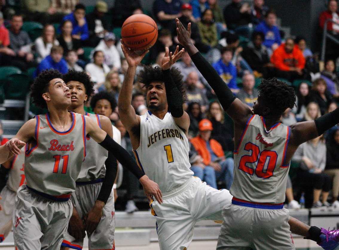 Marcus Tsohonis (1), driving on Stevie Smith (11) and Javion Garrett (20), led Jefferson with 22 points Monday night.