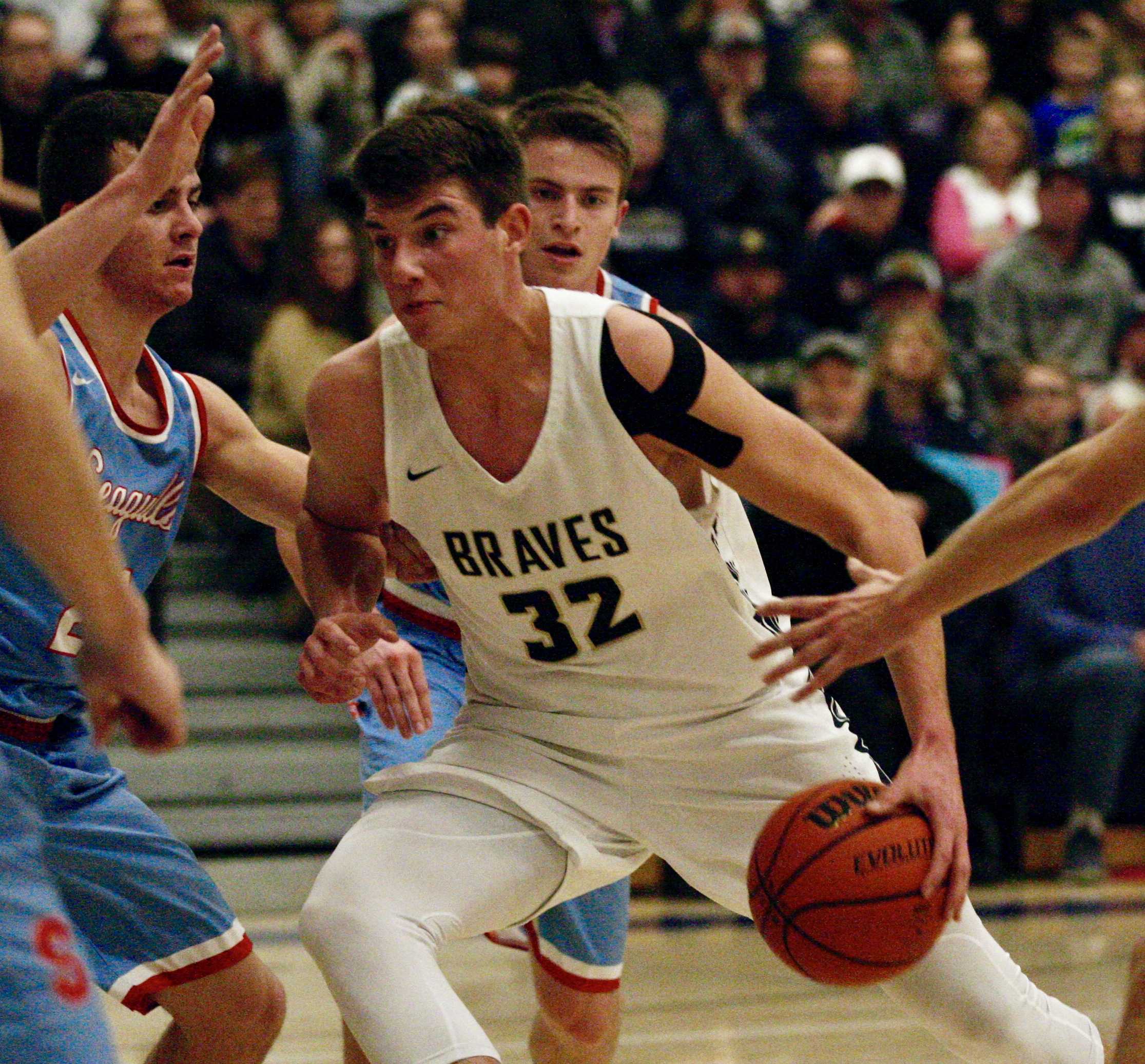 Banks senior Blake Gobel drives into Seaside's Duncan Thompson for two of his game and career-high 21 points in Braves' win.