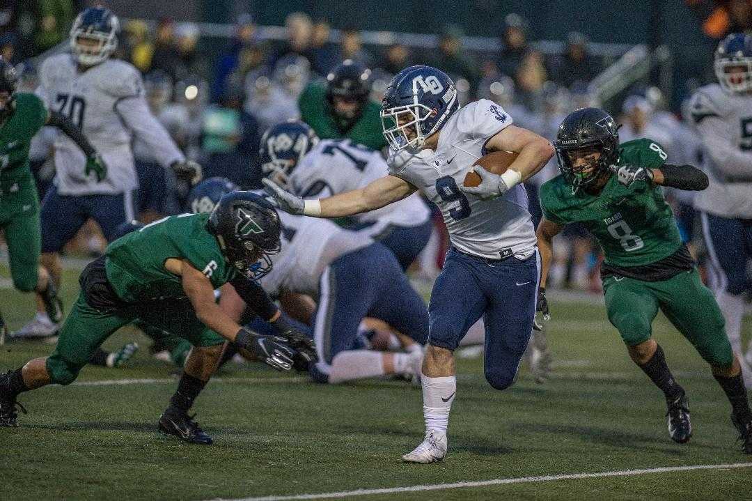 Tigard's Max Lenzy (6) and Josh Burns (8) close in on Lake Oswego's Casey Filkins (9). (Photo by Ralph Greene)