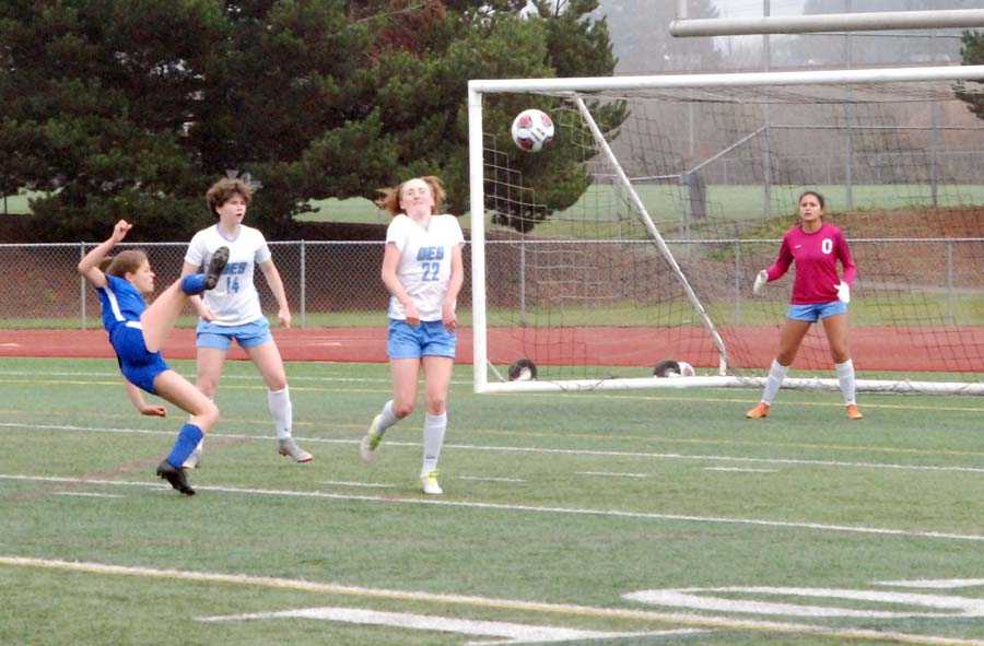 Caroline Cook (in blue) tries an acrobatic shot while Grace Armstrong (14), Wylly Willmott (22) and Izzy Ponce defend