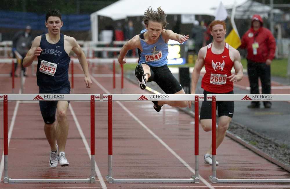 Luke Neville is first over the hurdle in this 100-meter race. Photo by Miles Vance