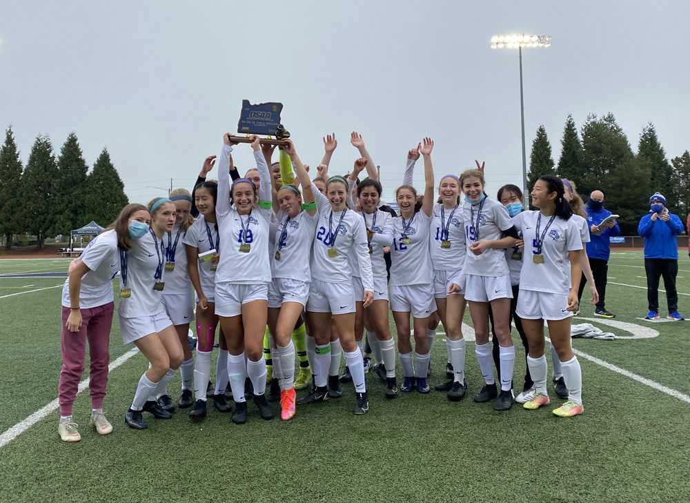 Catlin Gabel celebrates with the blue trophy after winning state for the second consecutive season (2019 and 2021)