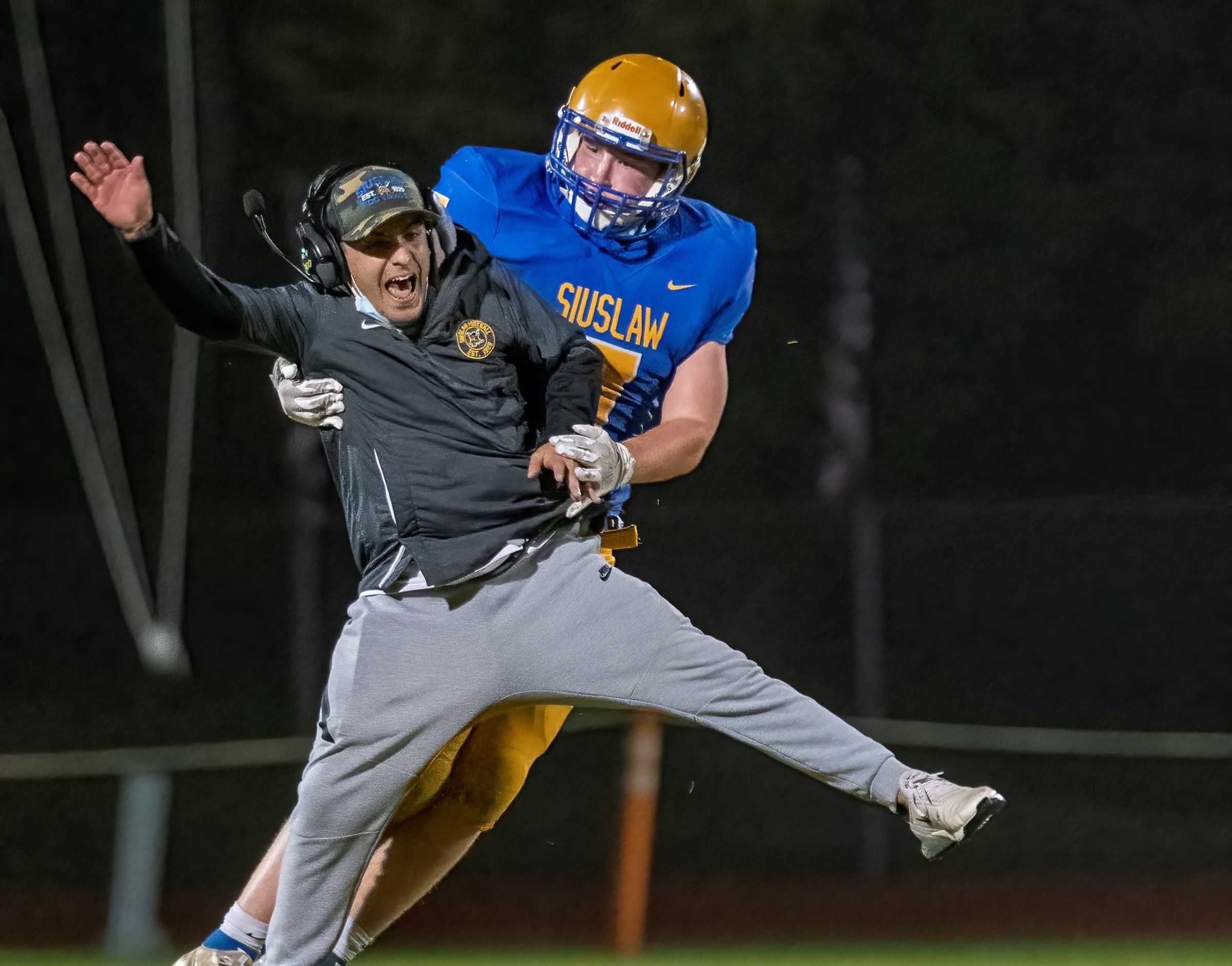 Siuslaw coach Sam Johnson, with junior Ian Sissel, led the team to a 3A title in his third season. (Photo by Cameron Jagoe)
