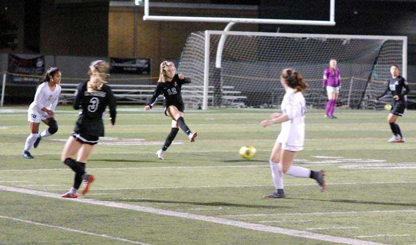 Payton Mongelli (12) moves the ball forward for Clackamas. The Cavaliers won the second-round match, 3-1