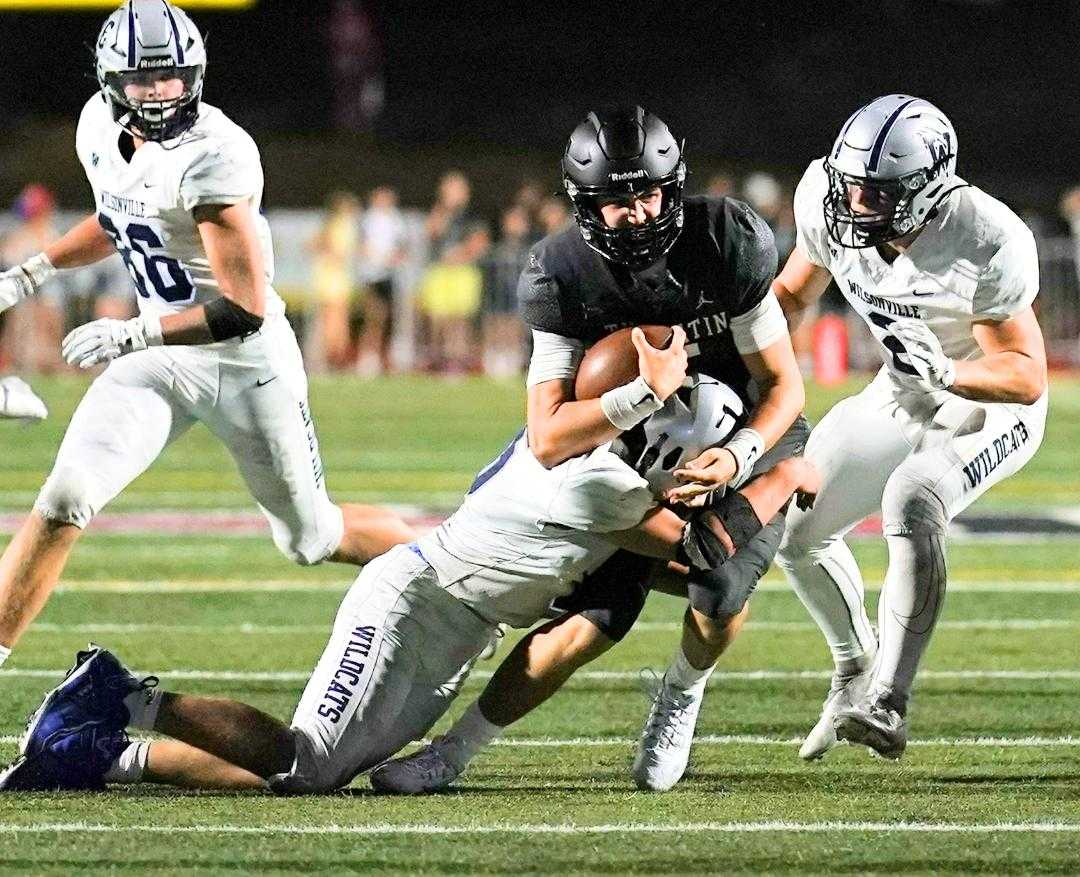 Quarterback Nolan Keeney fights for yards Friday night in Tualatin's 22-13 home win over Wilsonville. (Photo by Jon Olson)