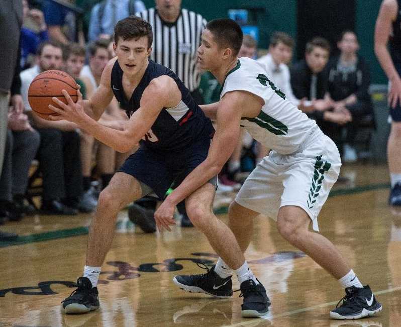 Lake Oswego's Sam Abere (left) works against the defensive pressure of Tigard's Jazz Ross. (Photo by Ralph Greene)