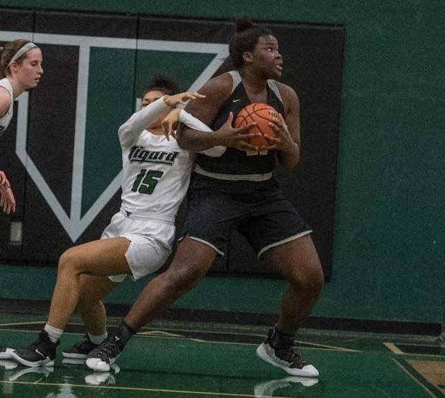 West Linn's Aaronette Vonleh fights through Tigard's Ajae Holdman on her way to the basket. (Photo by Ralph Greene)