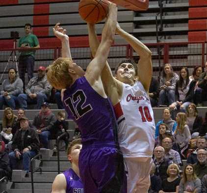 Oregon City's Corban Remsburg (10) is challenged at the rim by South Eugene's Aidan Clark. (Photo by Tamara Peyton)